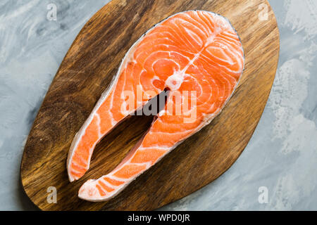 Crudo fresco pesce Salmone bistecca su pietra scura sullo sfondo. Layout creativi a base di pesce, vista dall'alto, piana, laici mockup, overhead. Cibo sano concetto Foto Stock