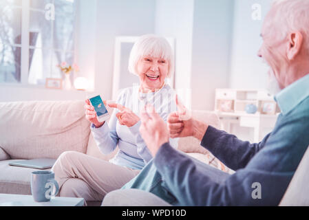 Coppia di pensionati sensazione emozionato dopo controllo previsioni meteo Foto Stock