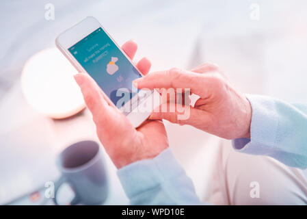 Donna anziana tenendo il telefono mentre si verifica previsioni meteo Foto Stock