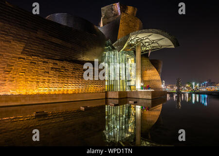 Scenic vista notturna del museo Guggenheim progettato da Frank Gehry accesa e riflessa nelle acque. Bilbao, Paesi Baschi, Gennaio 2019 Foto Stock