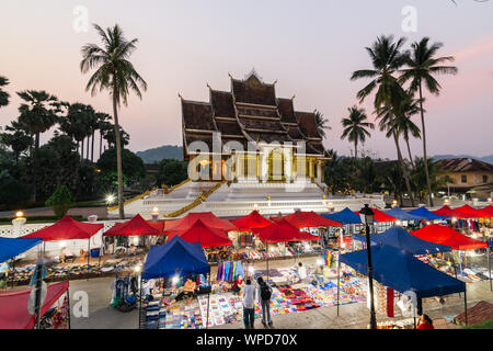 Luang Prabang, Laos - Maggio 2019: Mercato notturno con il palazzo reale e il museo nazionale in background. Foto Stock
