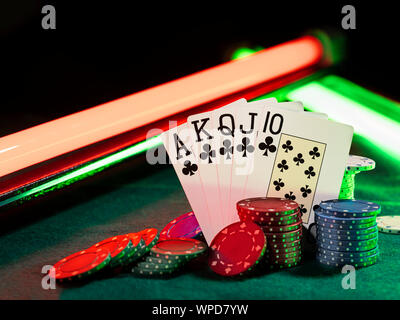 Close-up foto della combinazione vincente nel poker in piedi poggiando su chip multicolore pile, alcuni di loro sono nelle vicinanze di posa su un coperchio verde di un Foto Stock