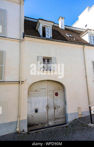 Street con piani casa residenziale con open persiane di legno e mansarde residenziale e porte ad arco - un classico del design architettonico della vecchia Parigi su Foto Stock