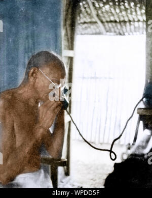 Il Mahatma Gandhi parlando al telefono da office capanna, Wardha, India, Asia, 1940 Foto Stock