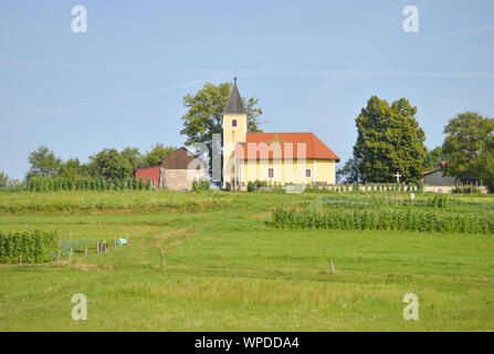 Villaggio Dragonoš in Croazia, terreni coltivati, Chiesa sulla sommità della collina Foto Stock