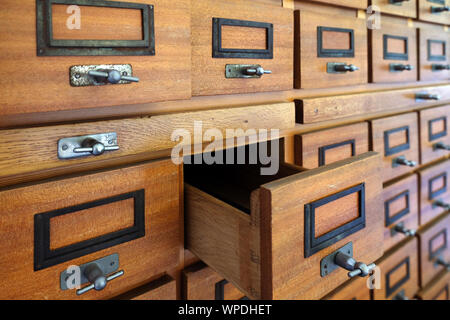 Vintage Filing cabinet in legno con molti cassetti per organizzare l'archivio. Un cassetto aperto Foto Stock