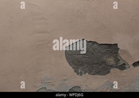 Il vecchio muro beige con un foro in gesso Foto Stock