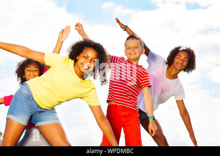 Gruppo di bambini sorriso di piegatura, insieme pendente Foto Stock