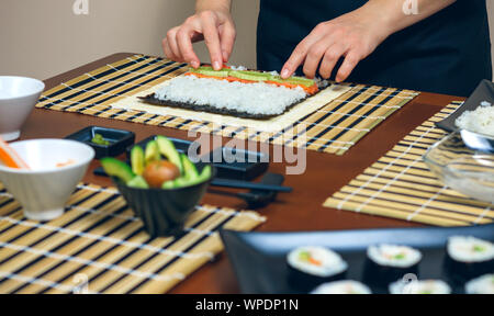 Chef ponendo le mani gli ingredienti sul riso Foto Stock