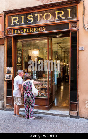 Un paio di turisti in cerca di un negozio tradizionale su Via Fillungo, una strada famosa per lo shopping, a Lucca, Toscana, Italia. Foto Stock