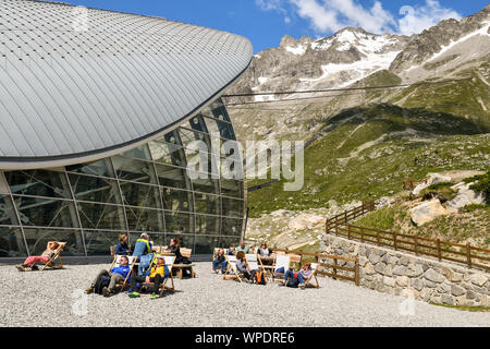 Esterno del Pavillon stazione della funivia del Skyway Monte Bianco con turisti ed escursionisti rilassarsi e prendere il sole sulle sdraio, Courmayeur, Italia Foto Stock