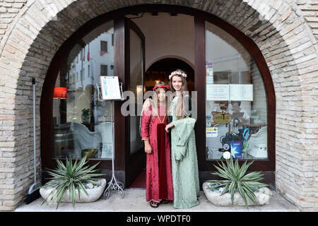 Vestito a festa le ragazze in abiti medievali durante l'annuale festival storici La Macia di fronte all'Enoteca La Torre. Spilimbergo, Italia Foto Stock