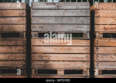 Cassette di legno vuote e casuali impilate contro un muro. Una