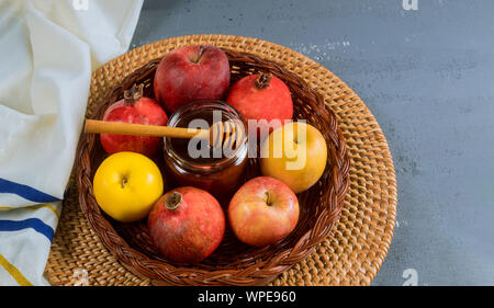 Versando il miele su apple e melograno con simboli di miele ebraica di Nuovo Anno Rosh Hashanah. Foto Stock