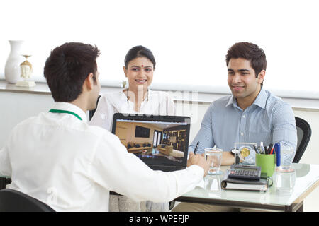 Real estate agent with couple in a office Stock Photo