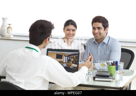 Real estate agent with couple in a office Stock Photo