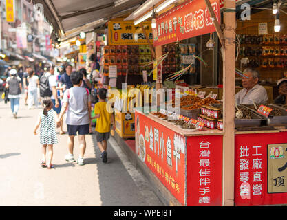 Taipei, Taiwan: il vecchio uomo essiccata la vendita di pesce e frutti di mare nella sua piccola cucina di strada stallo in Tamsui (Danshui) vecchia strada nella periferia di Taipei Foto Stock