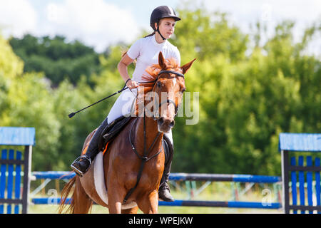 Femmina e giovane cavaliere a cavallo su sport equestri di concorrenza. Foto Stock