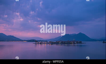 Una lunga esposizione la mattina presto il colpo di riflessi di luce dagli edifici sulla piccola isola del lago di Isola Bella italiana sul lago Maggiore. Foto Stock