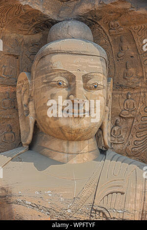 Colpo alla testa di una statua di Buddha in una nicchia di le grotte di Yungang nei pressi di Datong Foto Stock