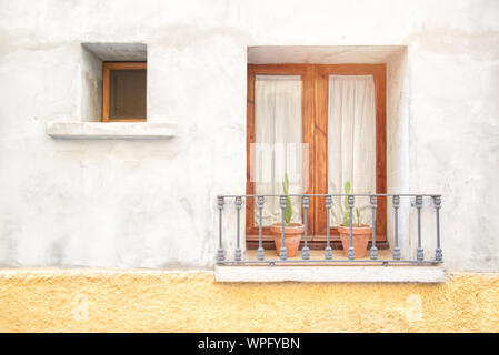 Tipica andalusa sfondo di strada in spagna con un balcone decorato con vasi da fiori e gerani. Svuotare lo spazio di copia per l'editor di testo. Foto Stock