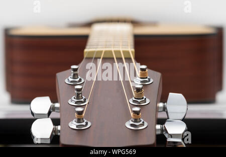 Close up di una chitarra acustica paletta su sfondo bianco. Foto Stock