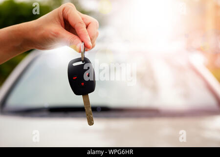 La mano di una donna in possesso di una chiave auto per essere presentato al conducente di questa vettura. Foto Stock
