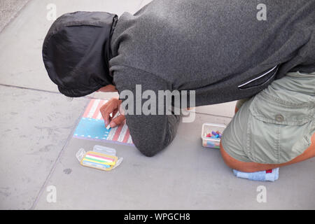 L'artista di strada su Trafalgar Square il disegno e la bandiera americana con un gessetto sul marciapiede. Londra, Regno Unito, Foto Stock