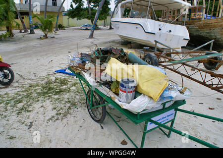 Un garbage su una spiaggia di corallo iniziativa di pulizia, Maafushi, Maldive. Foto Stock