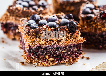 Materie vegano dessert di noce di cocco con mirtilli sulla scheda. Sano cibo vegan concetto. Foto Stock