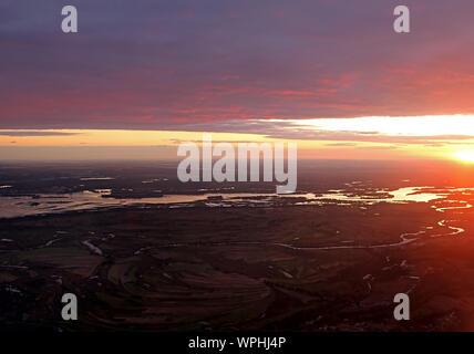 Colorato cielo drammatico con il cloud al tramonto sul fiume Dnipro e campi nei pressi di Kiev, Ucraina. Vista dal piano. Al tramonto i raggi del sole Foto Stock