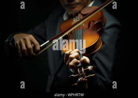 Uomo suona il violino sul tono scuro Foto Stock