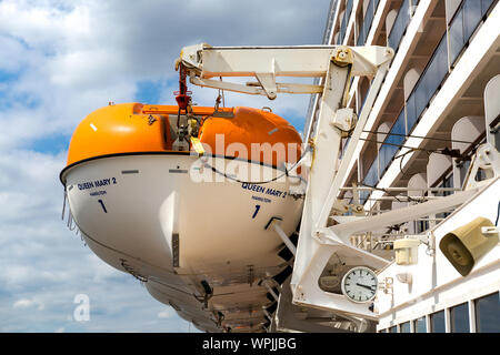 RMS Queen Mary 2. Stivate le imbarcazioni di salvataggio appeso sulla gru. Southampton Docks England Regno Unito Foto Stock