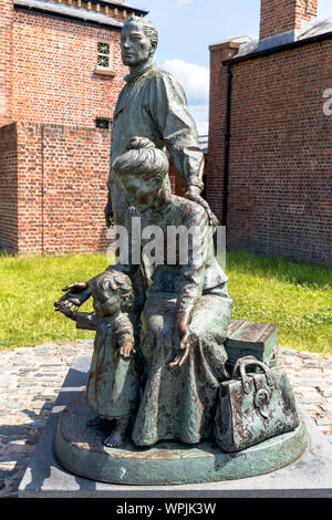 Scultura Legacy, 'l'attraversamento'. famiglia immigrata, dal marchio de Graffenried, porta, Liverpool, Merseyside England, Regno Unito Foto Stock