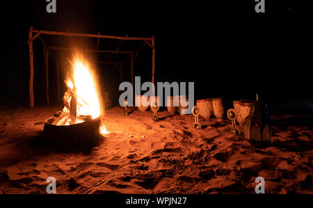 Tradizionali Berbere camp a notte. Il falò, pelle tamburi ed altri strumenti musicali Gli strumenti musicali sono in attesa per gli spettatori Foto Stock