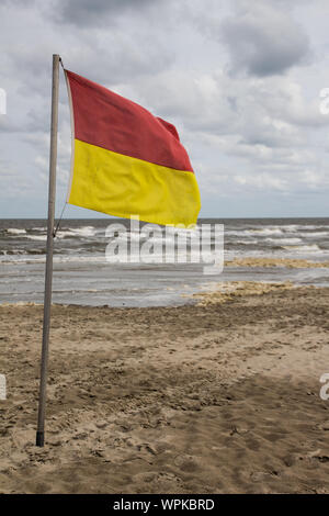 Un rosso e giallo di bandiera che dettaglia il bagnino in spiaggia a Nes Ameland, Foto Stock
