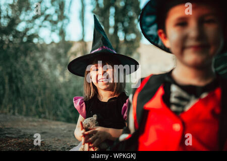 Due bambini mascherati per la festa di Halloween nel bosco Foto Stock