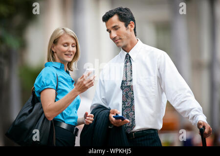 Metà adulto imprenditrice che mostra il suo cellulare a metà imprenditore per adulti. Foto Stock