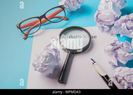 Curriculum vitae scritto su un vuoto di carta bianca su sfondo blu Foto Stock