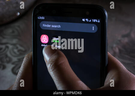 Uber mangia e airbnb app - una donna di controllo delle domande su uno smartphone Foto Stock