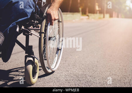 Giovane uomo disabili in carrozzella walking park Foto Stock