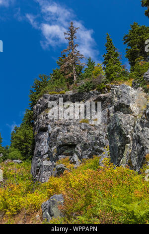 Vista sulle montagne e rocce lungo il lago di neve sentiero in Alpine Lakes Wilderness, Mt. Baker-Snoqualmie foresta nazionale, nello Stato di Washington, Foto Stock