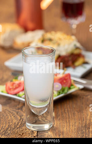 Ouzo greco con la moussaka su legno Foto Stock