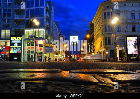 Berlino, Germania. 19 Ago, 2019. Serata foto dell'intersezione Zimmerstraße/Friedrichstraße in direzione di Kochstraße. In mezzo alla strada sorge l'ex Allied checkpoint di "Checkpoint Charlie", il più noto ex checkpoint tra Est e Ovest di Berlino. In primo piano una striscia di acciottolato segna il corso della ex-interna parete della città. Credito: Soeren Stache/dpa-Zentralbild/ZB/dpa/Alamy Live News Foto Stock