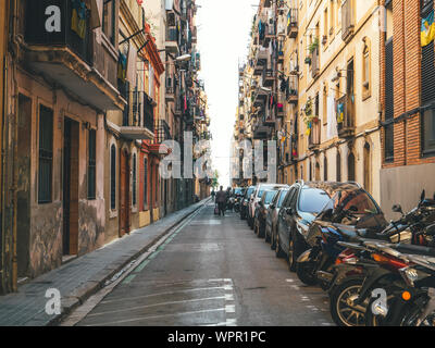 Barcellona, Spagna - Bov: 15, 2017: pedoni camminare tra alti architettura spagnola edifici appartamento su una piccola strada nel centro di Barcellona con popedes parcheggiata e automobili Foto Stock