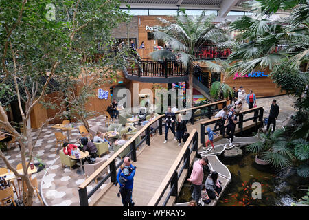 Settembre 2019. Famiglie presso la piazza principale area della Plaza shopping centre al Center Parcs La Foresta di Longleat, Wiltshire, Regno Unito Foto Stock