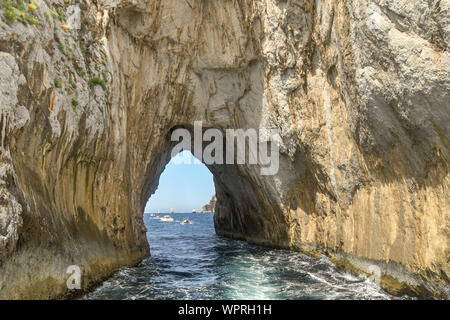 Isola di Capri - Agosto 2019: vista ravvicinata del tunnel ad arco in Faraglioni rock formazione al largo della costa di Capri. Foto Stock