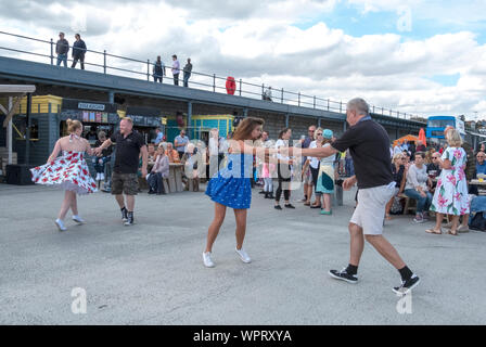 Balli swing su una domenica pomeriggio sul braccio del porto a Folkestone, Kent, Regno Unito Foto Stock