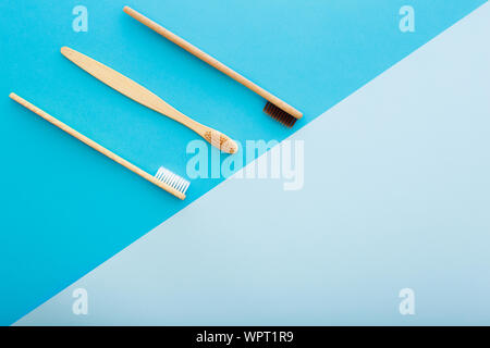 Per le cure dentarie con eco friendly bamboo spazzolino da denti su sfondo blu vista dall'alto. Rifiuti Zero e la plastica libera concetto. Foto Stock