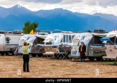 Donna di fotografare il suo partner nella parte anteriore di un campeggio Airstream trailer alla Airstream vintage Club Rocky Mountain Rally Foto Stock